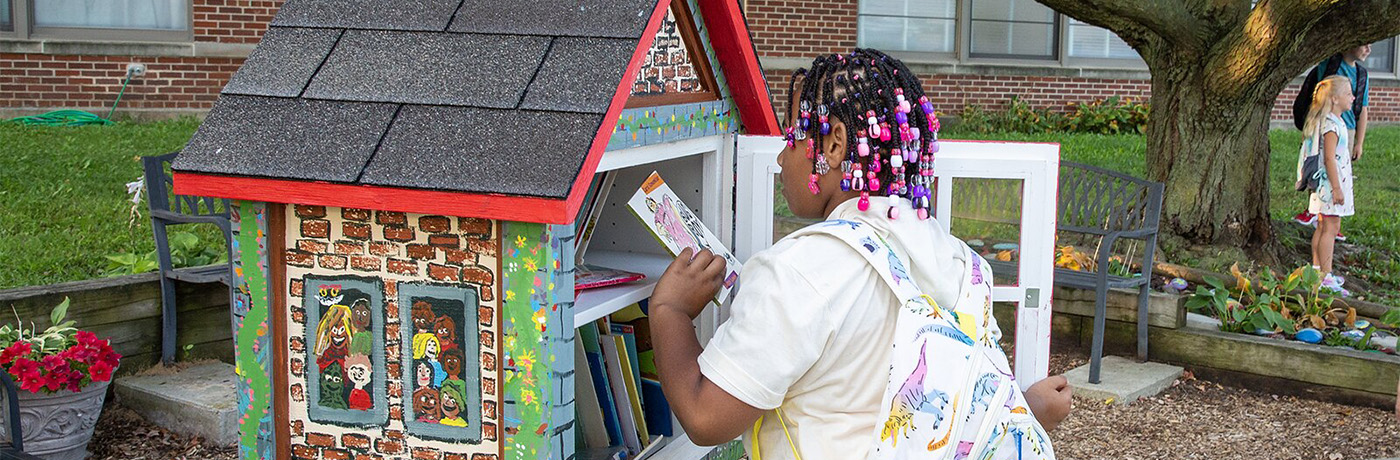 student looking at books in lending library